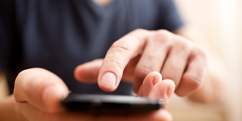 Close up of a man using mobile smart phone